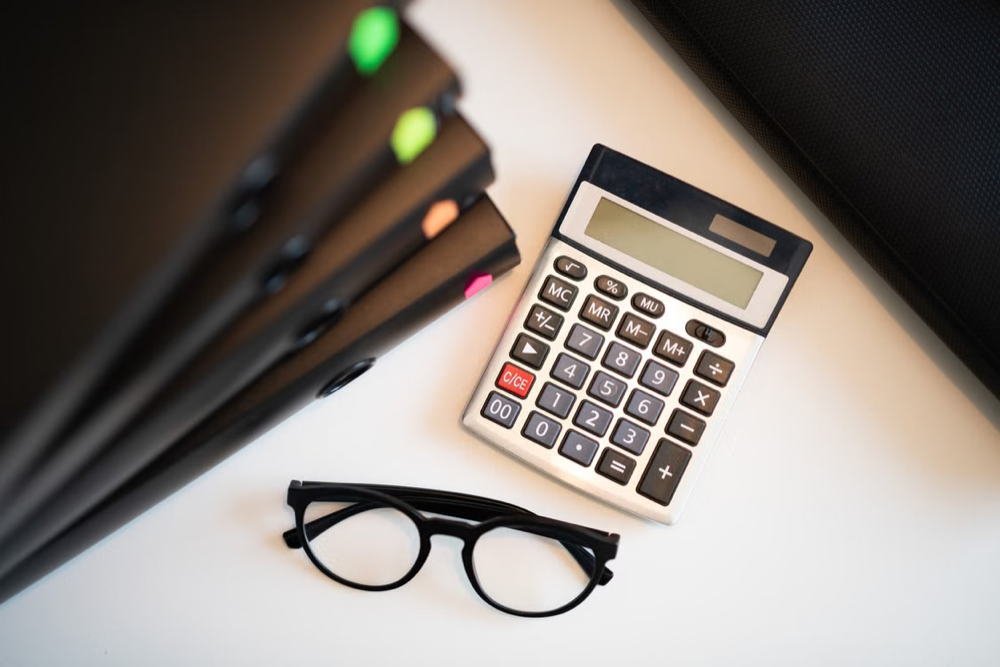 Pocket calculator, pens, and glasses