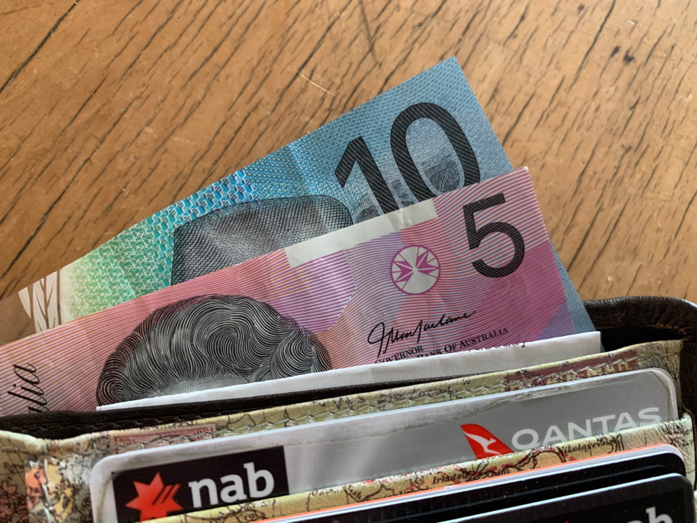 Australian dollar bills in a pocket together with bank cards