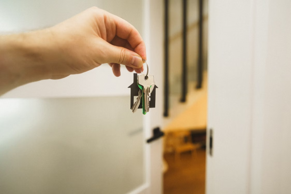 Man holding house key inside bright modern home