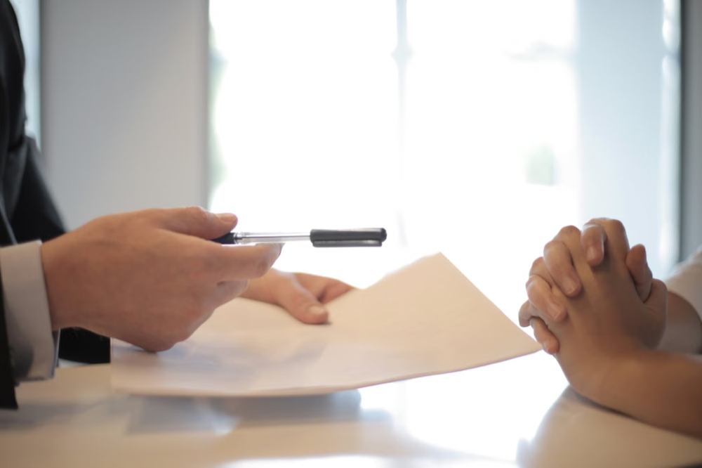 Businessman giving a paper for another person to sign