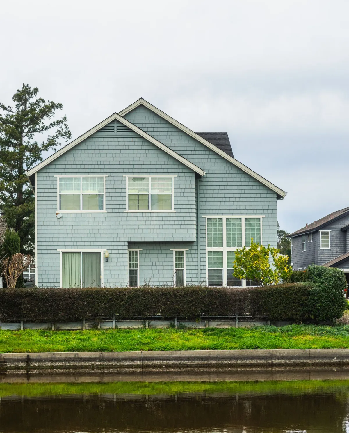 Suburban house with a canal in the foreground.