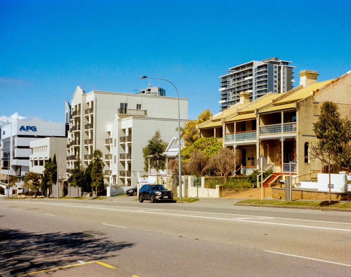 A street in Perth with many buildings and cars parked on it.