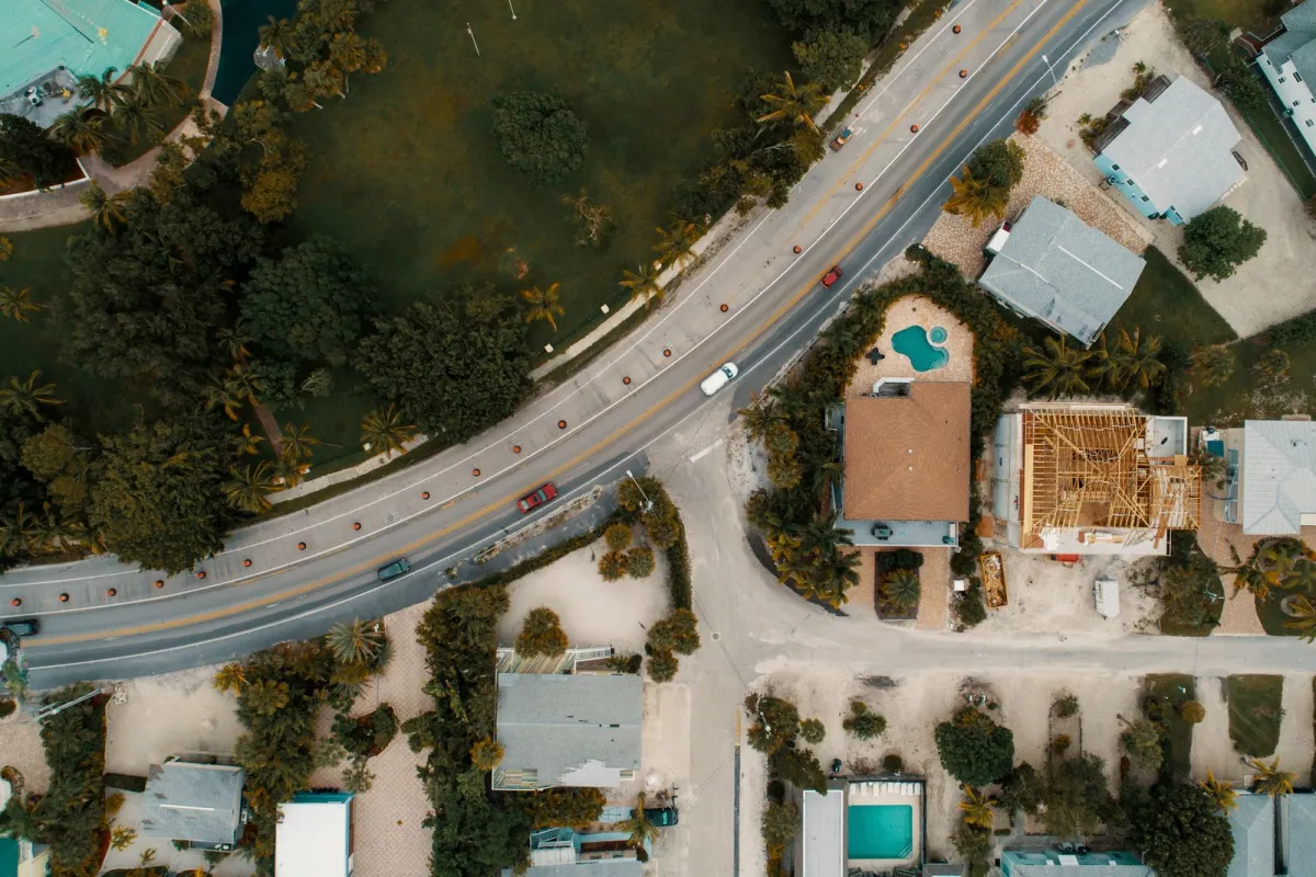 Aerial photography of vehicles on road beside houses.